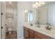 Well-lit bathroom with a double sink vanity, toilet, and shower offering both style and functionality at 4576 E Waterman St, Gilbert, AZ 85297
