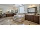 Luxurious bathroom featuring a sunken tub, dark wood cabinets, travertine floors and neutral decor at 4576 E Waterman St, Gilbert, AZ 85297