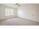 Bright bedroom with neutral carpet and white shutters filtering natural light through a large window at 4576 E Waterman St, Gilbert, AZ 85297