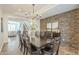 Dining room with modern chandelier, dark wood table, and a stone accent wall at 4576 E Waterman St, Gilbert, AZ 85297