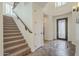 Bright foyer with a staircase, tile flooring with a decorative medallion, and a stylish front door at 4576 E Waterman St, Gilbert, AZ 85297