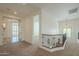Bright hallway with carpeted floor and decorative wrought iron railing, leading to multiple rooms in the home at 4576 E Waterman St, Gilbert, AZ 85297