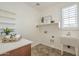 Bright laundry room with sink, ample shelving, and natural light, perfect for efficient chores at 4576 E Waterman St, Gilbert, AZ 85297