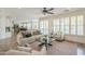 Spacious living area features plantation shutters, a ceiling fan, and a view into the kitchen at 4576 E Waterman St, Gilbert, AZ 85297