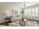 Bright living room featuring a neutral palette, decorative chandelier, and large windows with plantation shutters at 4576 E Waterman St, Gilbert, AZ 85297