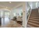 Open-concept living room and staircase featuring tile flooring, plantation shutters, and neutral décor at 4576 E Waterman St, Gilbert, AZ 85297