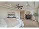 Inviting main bedroom with stone fireplace, tray ceiling, plush carpeting, and stylish furniture at 4576 E Waterman St, Gilbert, AZ 85297