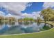 Pond surrounded by trees and grassy areas, with a cloudy blue sky reflected on the water's surface at 4576 E Waterman St, Gilbert, AZ 85297