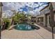 Resort style pool in backyard with mature landscaping, stone waterfall feature, built in BBQ, and covered patio at 4576 E Waterman St, Gilbert, AZ 85297