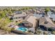 Aerial view of a backyard with a sparkling pool, a covered patio, and neat landscaping enclosed by a block fence at 4610 S Hassett Cir, Mesa, AZ 85212