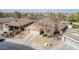 A high aerial view of a stucco home with a large driveway, a two-car garage, and desert landscaping at 4610 S Hassett Cir, Mesa, AZ 85212