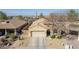 Aerial view of a well maintained one-story home featuring a two-car garage, neutral stucco exterior, and desert landscaping at 4610 S Hassett Cir, Mesa, AZ 85212