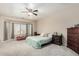Spacious bedroom with a large window, soft carpet, and coordinating furnishings at 4610 S Hassett Cir, Mesa, AZ 85212