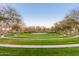 Expansive community park with walking paths, lush green lawns, and mature trees at 4610 S Hassett Cir, Mesa, AZ 85212