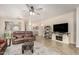 Bright living room featuring a ceiling fan, modern furniture, and tile flooring at 4610 S Hassett Cir, Mesa, AZ 85212