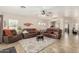 Spacious living room with tile flooring, ceiling fan, and comfortable leather furniture at 4610 S Hassett Cir, Mesa, AZ 85212