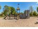 Community playground featuring a castle-themed playset with slides, climbing features, and ample shade at 4610 S Hassett Cir, Mesa, AZ 85212