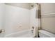 Bathroom with a white shower-tub combo, toilet, and a neutral-colored shower curtain at 4829 E Charleston Ave, Scottsdale, AZ 85254