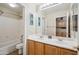 Well-lit bathroom featuring double sinks, a tub, toilet, and framed art pieces on the walls at 4829 E Charleston Ave, Scottsdale, AZ 85254