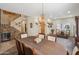 Open-concept dining room with elegant chandelier, staircase, and ample natural light from the large windows at 4829 E Charleston Ave, Scottsdale, AZ 85254