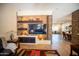 Living room with stone accent wall, floating shelves, built in storage, and view to dining area at 4829 E Charleston Ave, Scottsdale, AZ 85254