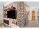 Open living space boasts a stone feature wall, built-in shelving, and staircase access at 4829 E Charleston Ave, Scottsdale, AZ 85254