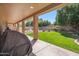 Covered patio overlooking a spacious backyard with green grass and a pool beyond a fence at 4829 E Charleston Ave, Scottsdale, AZ 85254