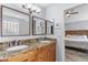Bathroom with double sinks, granite counters, wood cabinets, and access to the main bedroom at 5755 W Harrison St, Chandler, AZ 85226