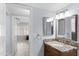 Bathroom with wood cabinets, granite counters, a mirror, and stylish light fixtures at 5755 W Harrison St, Chandler, AZ 85226
