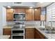 Modern kitchen features stainless steel appliances, granite countertops, and light wood cabinets at 5755 W Harrison St, Chandler, AZ 85226