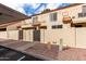 Exterior view of a townhouse complex with gated patios, covered parking, and stucco facade at 5808 E Brown Rd # 42, Mesa, AZ 85205