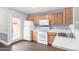 A bright kitchen with white appliances, wood cabinets, and access to the backyard at 5808 E Brown Rd # 42, Mesa, AZ 85205