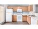 Charming kitchen showcasing white appliances, wooden cabinets, and wood-look vinyl flooring at 5808 E Brown Rd # 42, Mesa, AZ 85205
