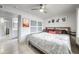 Bright bedroom showcasing a bed, a ceiling fan, and access to the bathroom at 6225 W Mary Jane Ln, Glendale, AZ 85306