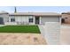 Charming single-story home features a manicured lawn, covered porch with chairs, and an attached two-car garage at 6225 W Mary Jane Ln, Glendale, AZ 85306
