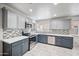 Updated kitchen with stainless steel appliances, gray cabinets, quartz countertops, and mosaic tile backsplash at 6225 W Mary Jane Ln, Glendale, AZ 85306