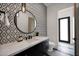 Stylish powder room with patterned tile accent wall, modern fixtures, and stone countertop at 7261 E Via Dona Rd, Scottsdale, AZ 85266