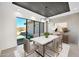 Dining area with modern table, chairs, textured accent wall, and large window views of the outdoor space at 7261 E Via Dona Rd, Scottsdale, AZ 85266