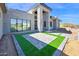 Modern home featuring a grand entryway with stone accents, an artificial turf design, and large windows at 7261 E Via Dona Rd, Scottsdale, AZ 85266