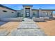 Contemporary home featuring a stone-clad entrance, striking dark-framed windows, and a welcoming walkway at 7261 E Via Dona Rd, Scottsdale, AZ 85266