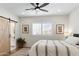 Cozy bedroom featuring a ceiling fan, wood floors, and natural light from the window at 7435 E Corrine Rd, Scottsdale, AZ 85260