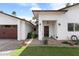 Inviting home featuring a manicured lawn, desert landscaping, and a striking solid wood front door with an ornate design at 7435 E Corrine Rd, Scottsdale, AZ 85260