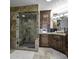 Elegant bathroom with a stone tile shower, custom wood cabinets, and stylish fixtures at 8240 E Pueblo Ave, Mesa, AZ 85208
