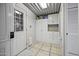 Well-lit laundry area features ample storage cabinets and utility sink near the door, perfect for organization at 8240 E Pueblo Ave, Mesa, AZ 85208