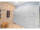 Bathroom featuring tiled walls, storage cabinets, and a wooden stool creating a practical space at 8401 N 55Th Ave, Glendale, AZ 85302