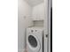 Convenient laundry area with a Whirlpool front load washer and overhead cabinets for storage at 8401 N 55Th Ave, Glendale, AZ 85302