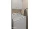 Practical laundry area with a white washing machine, storage cabinets, and ironing board at 8401 N 55Th Ave, Glendale, AZ 85302