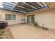 A covered patio features a grill, outdoor storage, and sliding glass doors leading indoors and bordered by desert landscaping at 8401 N 55Th Ave, Glendale, AZ 85302