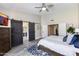 Bedroom featuring a large bed, ceiling fan, and barn doors leading to bathroom at 9032 E Larkspur Dr, Scottsdale, AZ 85260
