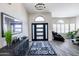 Bright foyer with modern light fixture, half-moon window, stylish decor and wood-look flooring at 9032 E Larkspur Dr, Scottsdale, AZ 85260